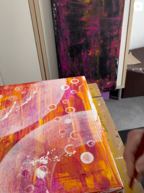 Handgemaltes abstraktes Acrylbild in Orange- und Pinktönen während des kreativen Malprozesses