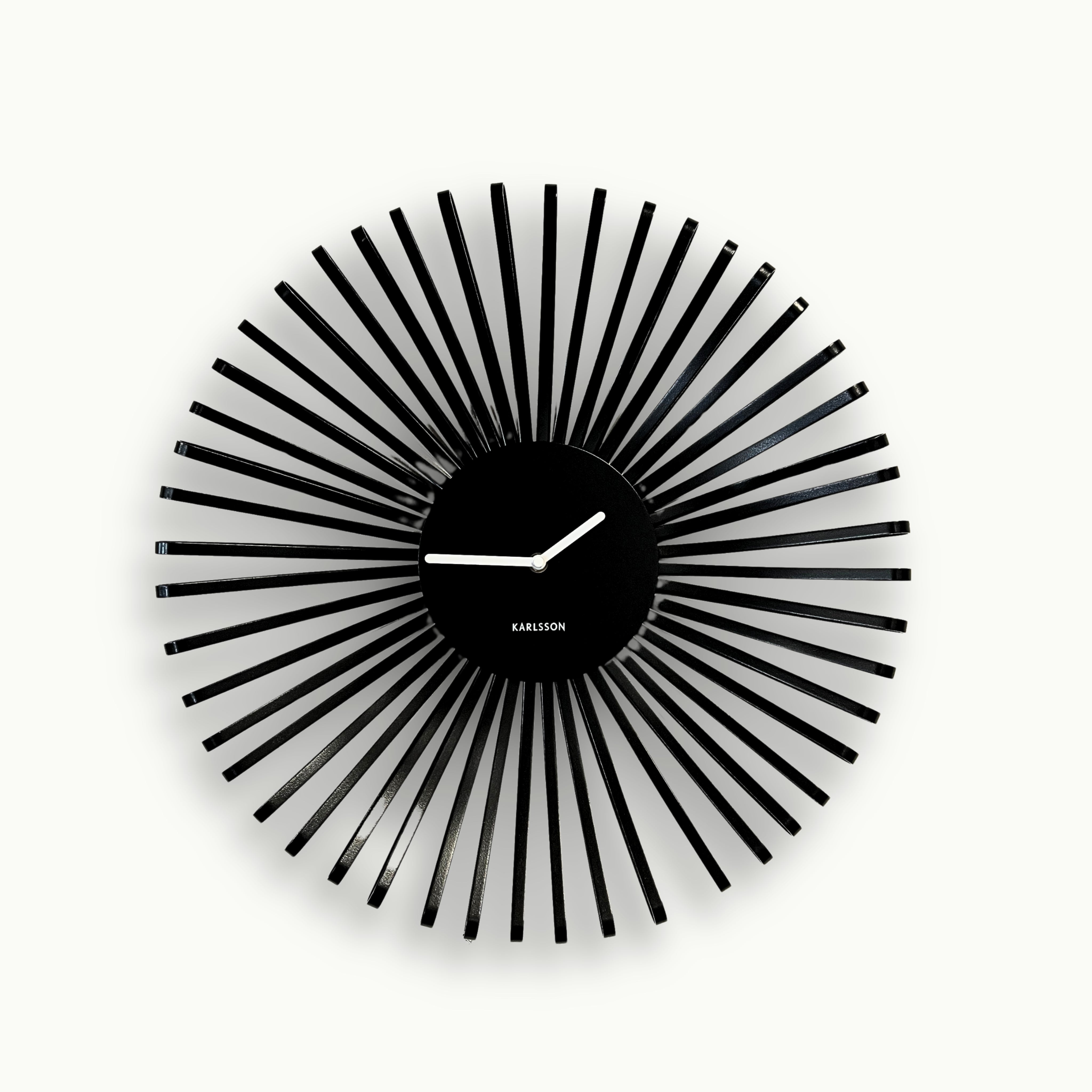 Moderne schwarze Metall-Wanduhr von Atelier B mit dekorativer Sunburst-Struktur und weißen Zeigern, Durchmesser 48 cm.