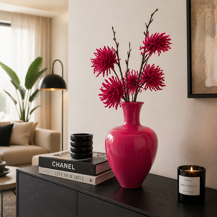 Moderne pinke Metallvase dekoriert auf einer Kommode im stilvollen Wohnzimmer