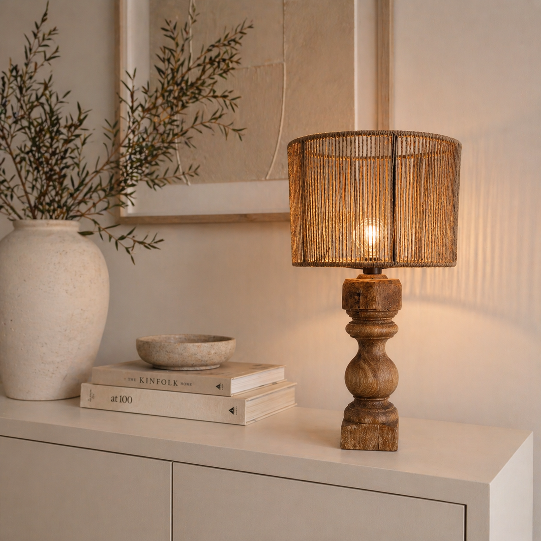Moderne Tischlampe aus Holz mit geflochtenem Schirm auf heller Kommode im minimalistischen Wohnstil