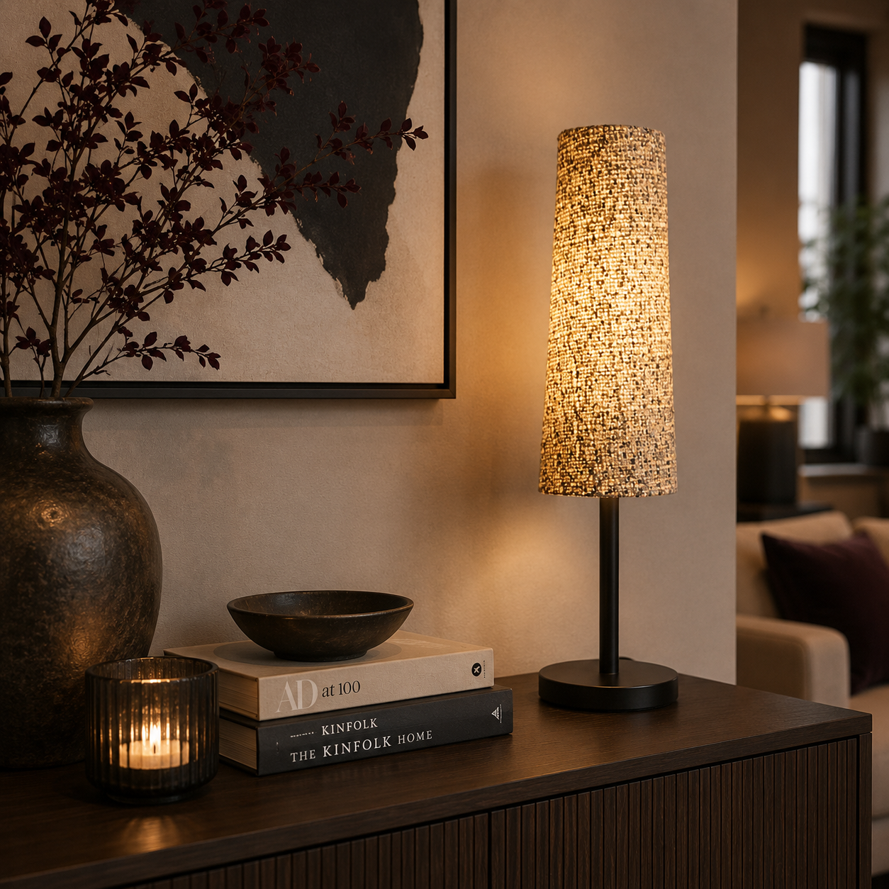 Moderne Tischlampe von Atelier B mit strukturiertem Stoffschirm und warmem Licht auf einem eleganten Sideboard. Die Lampe wird von farblich abgestimmter Dekoration, Kerzenlicht und stilvollen Wohnaccessoires in einem modern eingerichteten Wohnzimmer harmonisch ergänzt.