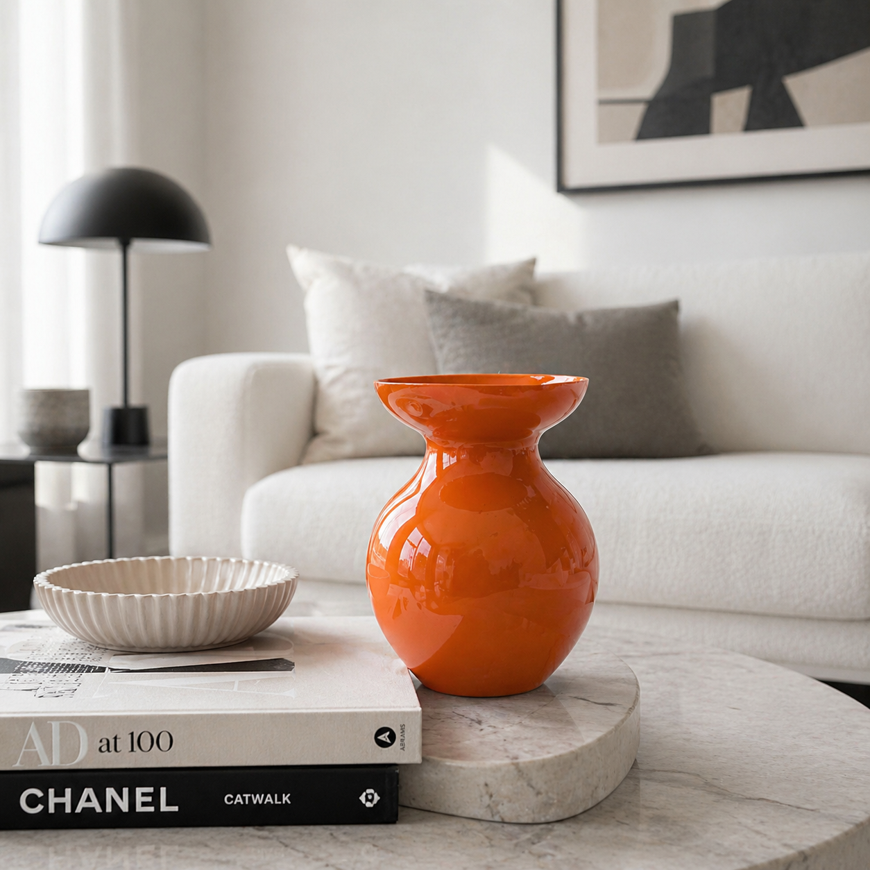 Moderne orange Vase als stilvolle Tischdekoration in einem hellen, minimalistisch eingerichteten Wohnzimmer mit neutralen Farben