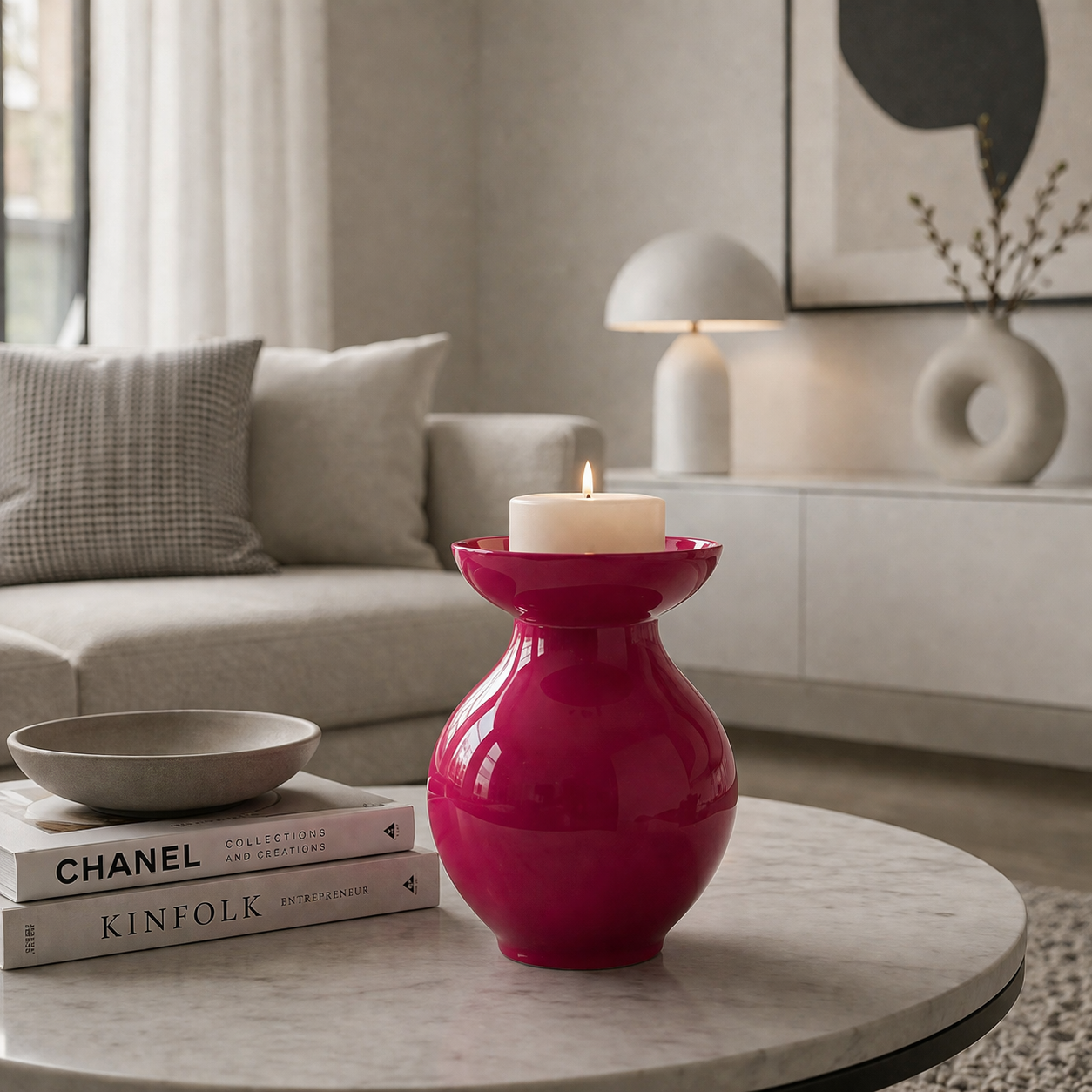 Rote dekorative Vase mit Kerze als stilvolle Tischdekoration in einem modern eingerichteten Wohnzimmer im minimalistischen weiß-grauen Stil