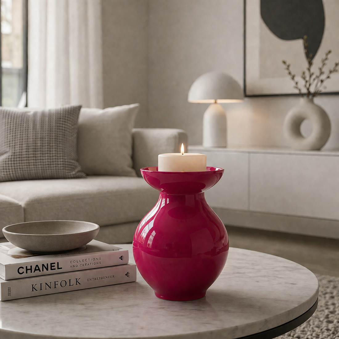 Rote dekorative Vase mit Kerze als stilvolle Tischdekoration in einem modern eingerichteten Wohnzimmer im minimalistischen weiß-grauen Stil