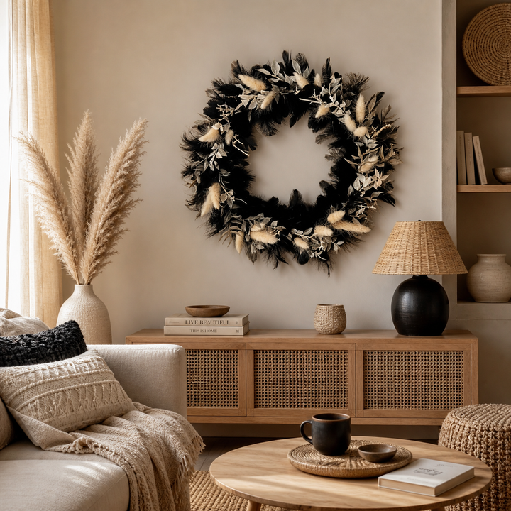 Boho Wandkranz aus schwarzen Federn und hellen Trockenblumen als dekorative Wanddeko in einem gemütlichen Wohnzimmer mit warmen Naturfarben