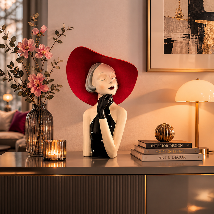 Elegante Dekofigur einer Frau mit rotem Hut auf einem Sideboard, kombiniert mit stilvoller Dekoration, Kerzen und warmem Licht in einem luxuriösen Wohnzimmer