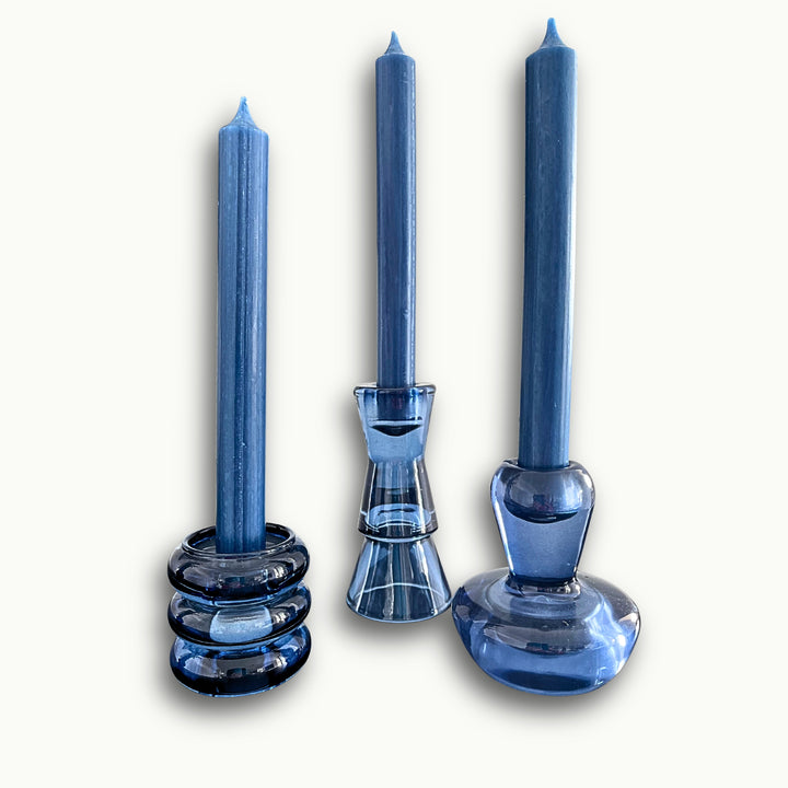 Elegante Kerzenständer aus blauem Glas mit eingesetzten Stabkerzen