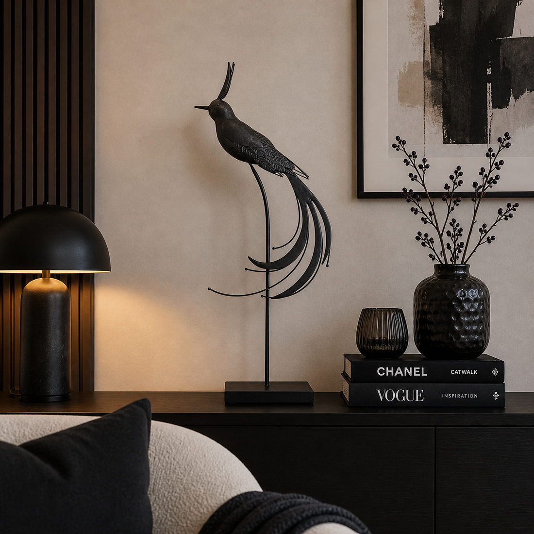 Elegante schwarze Metallvogel-Dekofigur auf einem Ständer, dekoriert auf einer modernen Kommode in einem stilvoll eingerichteten Wohnzimmer mit schwarzen Akzenten und warmer Beleuchtung.