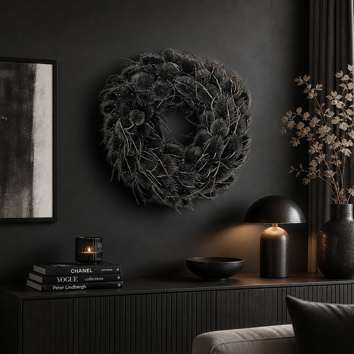 Schwarzer Naturkranz als Wanddeko an einer dunklen Wand über einem Sideboard in einem modernen, minimalistischen Wohnzimmer mit eleganter Beleuchtung